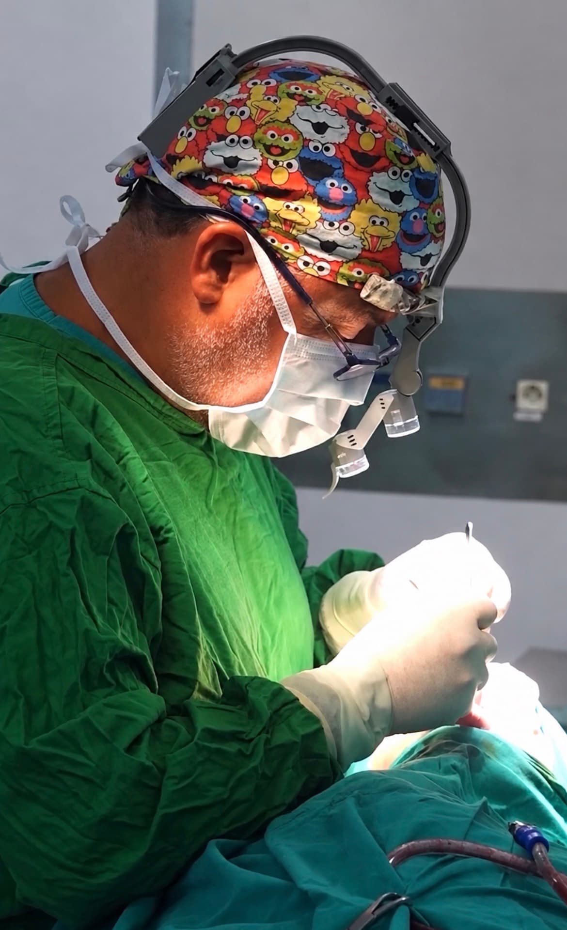 Dr. Bassem Karam wearing surgical attire and magnifying loupes